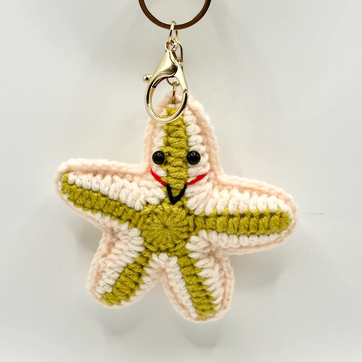 Lime green crochet starfish charm with a smiling face