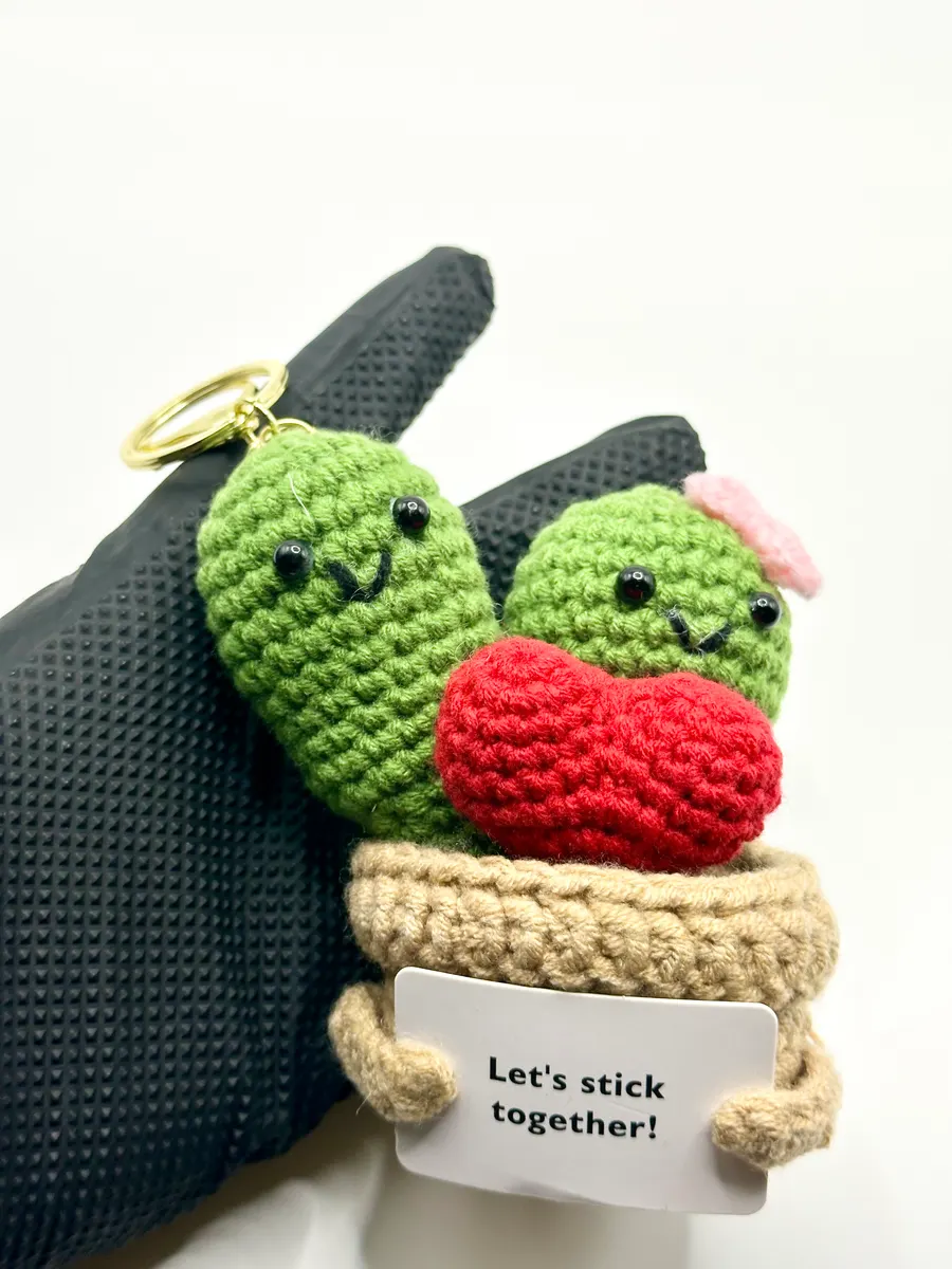 Crochet cactus pair and red heart in a pot keychain holding a Let's stick together card