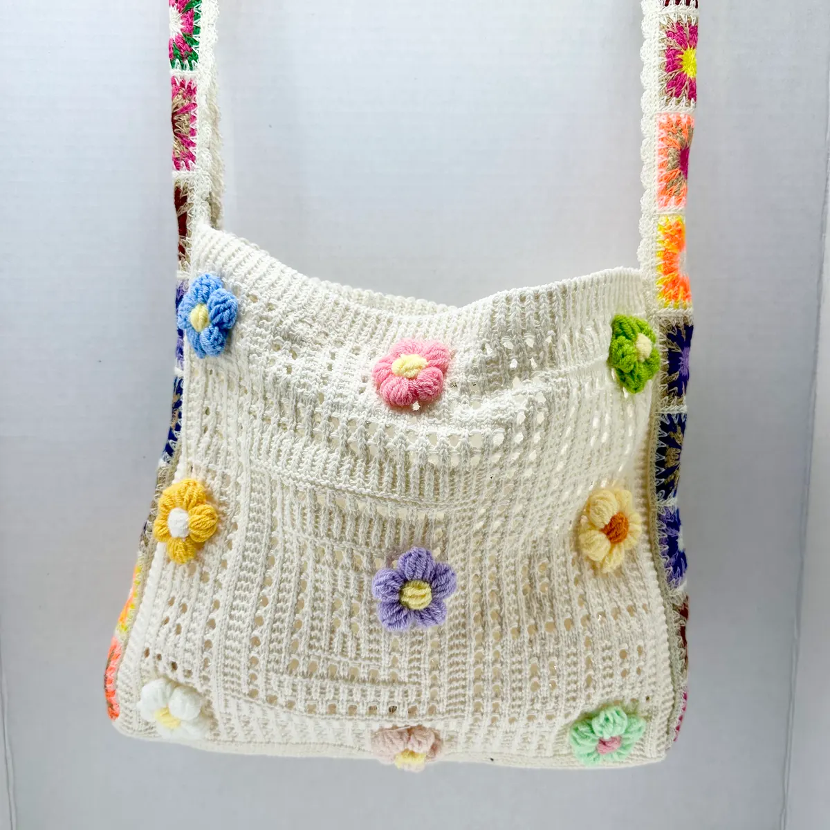 Cream open-weave shoulder bag with colorful crochet flowers
